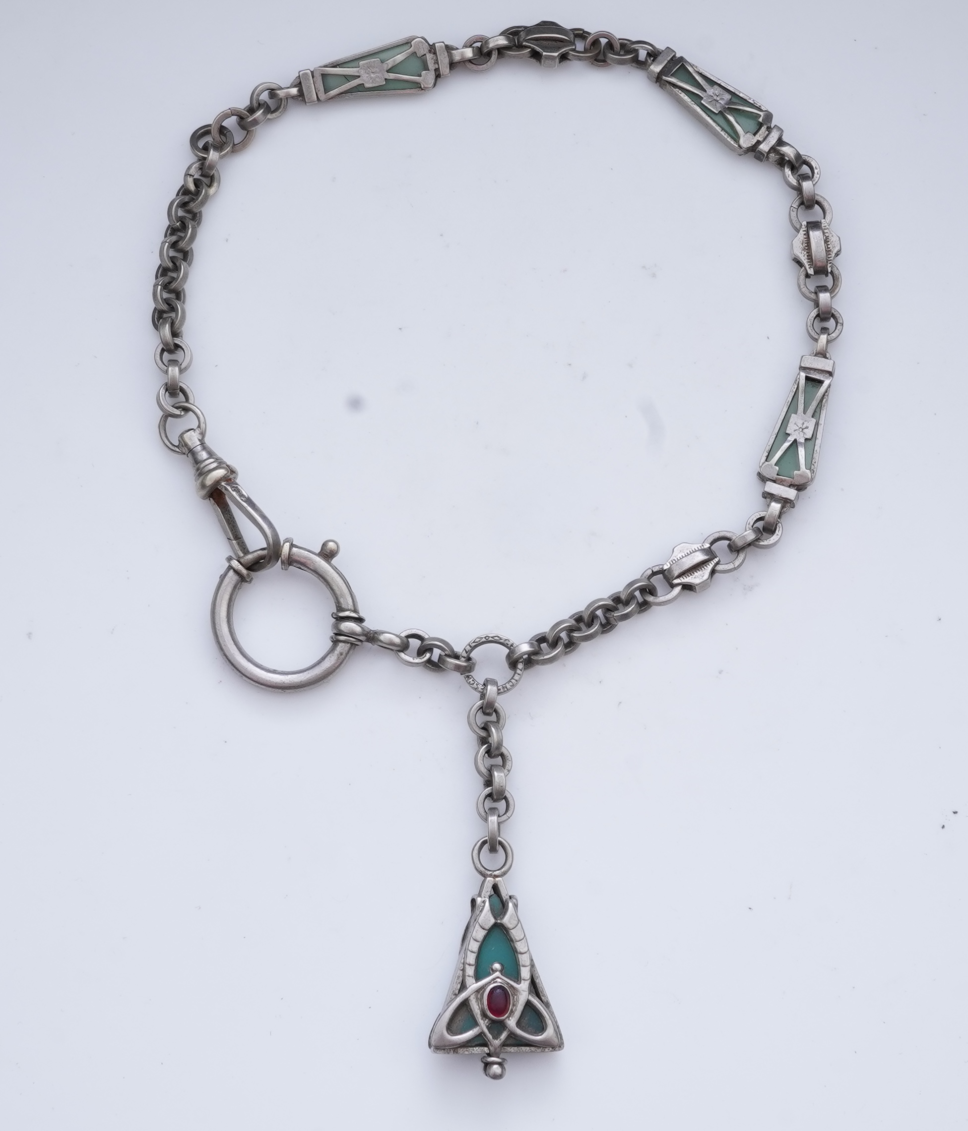 A collection of three silver chains and an Art Nouveau brooch, early 20th century